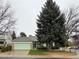 Charming single-story home with a green exterior, attached garage, mature trees, and well-kept landscaping at 9806 Hooker Ct, Westminster, CO 80031