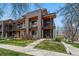Modern townhouse with brick and wood accents, multiple balconies, and a well-manicured lawn at 3201 W 25Th Ave, Denver, CO 80211