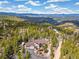 Stunning mountain home nestled among trees with a long driveway and incredible mountain views at 1140 Indian Peak Rd, Golden, CO 80403