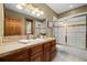 Well-lit bathroom features a granite countertop, wooden cabinets, and a tiled shower with glass doors at 1140 Indian Peak Rd, Golden, CO 80403