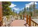 Relaxing deck with rocking chairs surrounded by lush green trees and blue skies at 1140 Indian Peak Rd, Golden, CO 80403