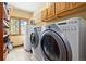 Spacious laundry room equipped with modern washer and dryer, shelving, and natural light at 1140 Indian Peak Rd, Golden, CO 80403