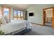 Spacious main bedroom with a mounted TV and large windows offering picturesque outdoor views at 1140 Indian Peak Rd, Golden, CO 80403
