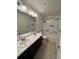 Bright bathroom featuring a double sink vanity and a shower-tub combo with decorative gray and white tile at 14883 E Crestridge Dr, Centennial, CO 80015
