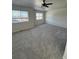 Spacious bedroom featuring neutral carpet, ceiling fan, and sunlit windows at 14883 E Crestridge Dr, Centennial, CO 80015