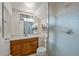 Bathroom featuring a wooden vanity with sink and framed mirror, alongside a glass door shower at 10874 Pearl Ct, Northglenn, CO 80233