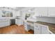 Well-lit kitchen showcasing white cabinets, stainless appliances, and a functional desk area at 10874 Pearl Ct, Northglenn, CO 80233