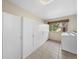 Functional laundry room features tile flooring, white cabinetry, and a window for natural light at 10874 Pearl Ct, Northglenn, CO 80233