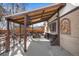 Covered patio with built-in seating and a fire pit, extending from the brick house at 10874 Pearl Ct, Northglenn, CO 80233