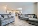 Comfortable living room features modern gray couches and is open to the eat-in kitchen at 14758 Normande Dr, Mead, CO 80542