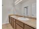 Bathroom with a double sink vanity, large mirror, and neutral countertop at 9816 Kalispell St, Commerce City, CO 80022