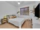 Comfortable bedroom with natural light, a wooden bed frame, and a television at 9816 Kalispell St, Commerce City, CO 80022