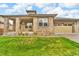 Charming home showcasing lush green lawn, brick accents, and an inviting front porch at 9816 Kalispell St, Commerce City, CO 80022