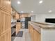 Traditional kitchen with wood cabinets, stainless steel appliances, and breakfast bar at 9816 Kalispell St, Commerce City, CO 80022