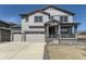 Two-story home with gray siding, stone accents, three-car garage, covered porch, and well-manicured lawn at 2968 S Poppy St, Morrison, CO 80465