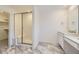 Elegant main bathroom featuring a glass-enclosed shower, marble-look flooring, and a modern vanity at 2968 S Poppy St, Morrison, CO 80465