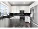 Modern kitchen with white cabinetry, black countertops, and stainless steel appliances offers sleek design at 13181 Grant W Cir # B, Thornton, CO 80241