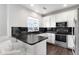 Modern kitchen features sleek black countertops, stainless steel appliances, and ample white cabinetry for storage at 13181 Grant W Cir # B, Thornton, CO 80241