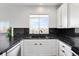 Bright kitchen with black countertops, subway tile backsplash, and white cabinets create a striking contrast at 13181 Grant W Cir # B, Thornton, CO 80241