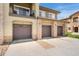 Townhome garages with individual doors, stone accents, and well-maintained driveways at 2239 Calais Dr # 11F, Longmont, CO 80504