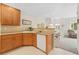 Functional kitchen with wooden cabinets, white appliances, and view to dining area at 2239 Calais Dr # 11F, Longmont, CO 80504