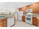 Functional kitchen with white appliances, wooden cabinets, and a view to the living area at 2239 Calais Dr # 11F, Longmont, CO 80504