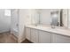Well-lit bathroom featuring double sinks, quartz countertop, and shower-tub combo at 6616 N Nepal St, Aurora, CO 80019