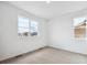 Bright, carpeted bedroom with two windows offering neighborhood views at 6616 N Nepal St, Aurora, CO 80019