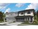 Modern two-story home boasts stone accents, neutral siding, and a dark roof, set against a backdrop of lush trees at 6616 N Nepal St, Aurora, CO 80019