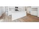Modern kitchen with white cabinetry, stainless steel appliances, large island with sink, and hard surface floors at 6616 N Nepal St, Aurora, CO 80019