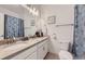 Bathroom featuring double sinks, modern lighting, framed art and a shell-themed shower curtain at 2214 Central Park Way, Superior, CO 80027