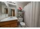 Bathroom with a single sink vanity, shelves, and a shower with a curtain at 10752 Steele St, Northglenn, CO 80233