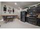 Modern kitchen with stainless steel appliances, dark cabinets, and an adjacent breakfast nook at 10752 Steele St, Northglenn, CO 80233