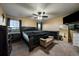 Spacious main bedroom featuring a ceiling fan, two windows, TV, and black furniture at 10752 Steele St, Northglenn, CO 80233