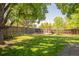 Large backyard with a well-maintained lawn, mature trees, and a patio area for outdoor dining at 1140 Devonshire Ct, Lafayette, CO 80026