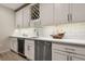 Close-up of modern basement bar area with white cabinets, wine storage, and stainless steel appliances at 11151 W 53Rd Dr, Wheat Ridge, CO 80033