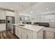 Open kitchen featuring stainless appliances, quartz counters, white cabinets, and access to living spaces at 11151 W 53Rd Dr, Wheat Ridge, CO 80033