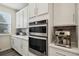 Bright kitchen featuring white cabinets, modern appliances, and stylish backsplash at 11151 W 53Rd Dr, Wheat Ridge, CO 80033