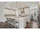 Elegant white kitchen featuring stainless steel appliances, a large island, and pendant lighting at 11151 W 53Rd Dr, Wheat Ridge, CO 80033