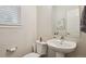 Cozy powder room featuring a pedestal sink and a modern mirror at 11151 W 53Rd Dr, Wheat Ridge, CO 80033