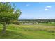 Scenic view of a lush green field with a tranquil pond and distant mountains under a clear blue sky at 11151 W 53Rd Dr, Wheat Ridge, CO 80033