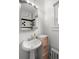 Cozy bathroom with sleek pedestal sink, storage and modern black and white tile accents at 1136 N Logan St # 8, Denver, CO 80203