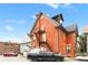 Three-story brick building featuring a fire escape, pitched roof, and off-street parking at 1136 N Logan St # 8, Denver, CO 80203
