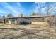 Expansive backyard featuring a brick home exterior, chimney, and mature trees under a bright blue sky at 328 Quay St, Lakewood, CO 80226