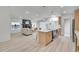 Open-concept living room with modern kitchen island, a stone fireplace, and neutral furniture on wood floors at 328 Quay St, Lakewood, CO 80226