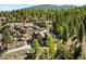 Aerial view of a log home nestled in a picturesque forest with surrounding rock outcroppings at 6150 Bluebell Ln, Evergreen, CO 80439