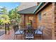 Outdoor deck featuring dining set, views of landscaping and rocky hillside at 6150 Bluebell Ln, Evergreen, CO 80439
