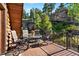 Outdoor deck area with table, chairs, and view of the surrounding trees and rock formations at 6150 Bluebell Ln, Evergreen, CO 80439