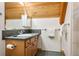 Bathroom with single sink, wood cabinetry, and a wood paneled ceiling at 6150 Bluebell Ln, Evergreen, CO 80439