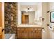 Bathroom featuring a rock-walled shower, tile floors, and a wood vanity with good lighting at 6150 Bluebell Ln, Evergreen, CO 80439